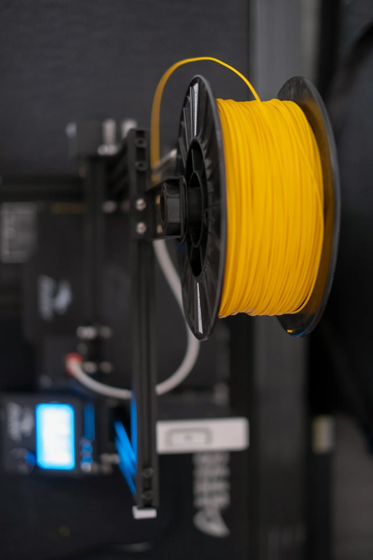 A Yellow filament spool mounted on 3d printer